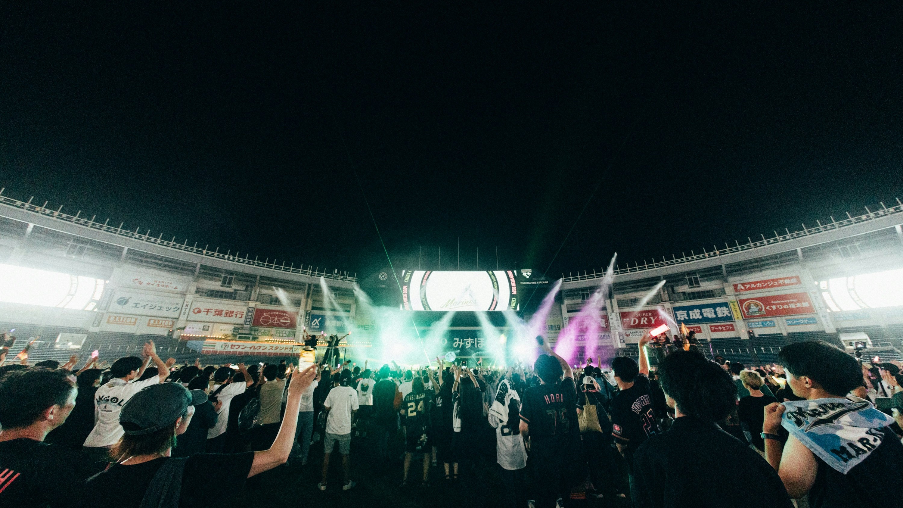 Aerial view of a massive outdoor concert event showing full venue and crowd